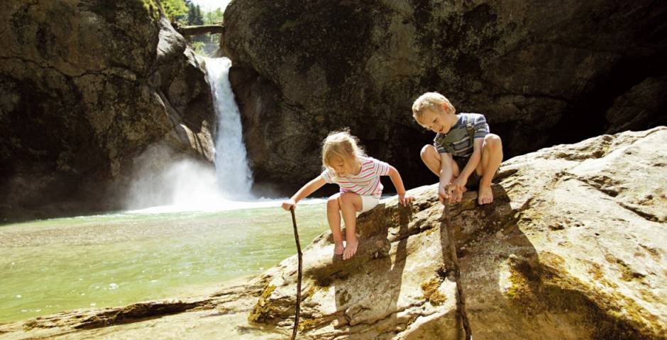 Zwei Kinder spielen am Bach